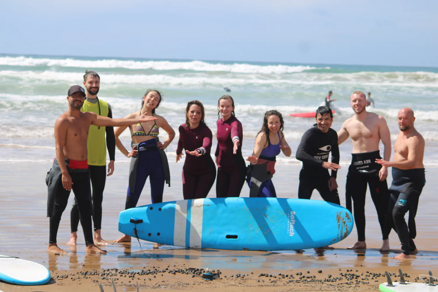 Un groupe de cours posant autour de planches bleues après une session.