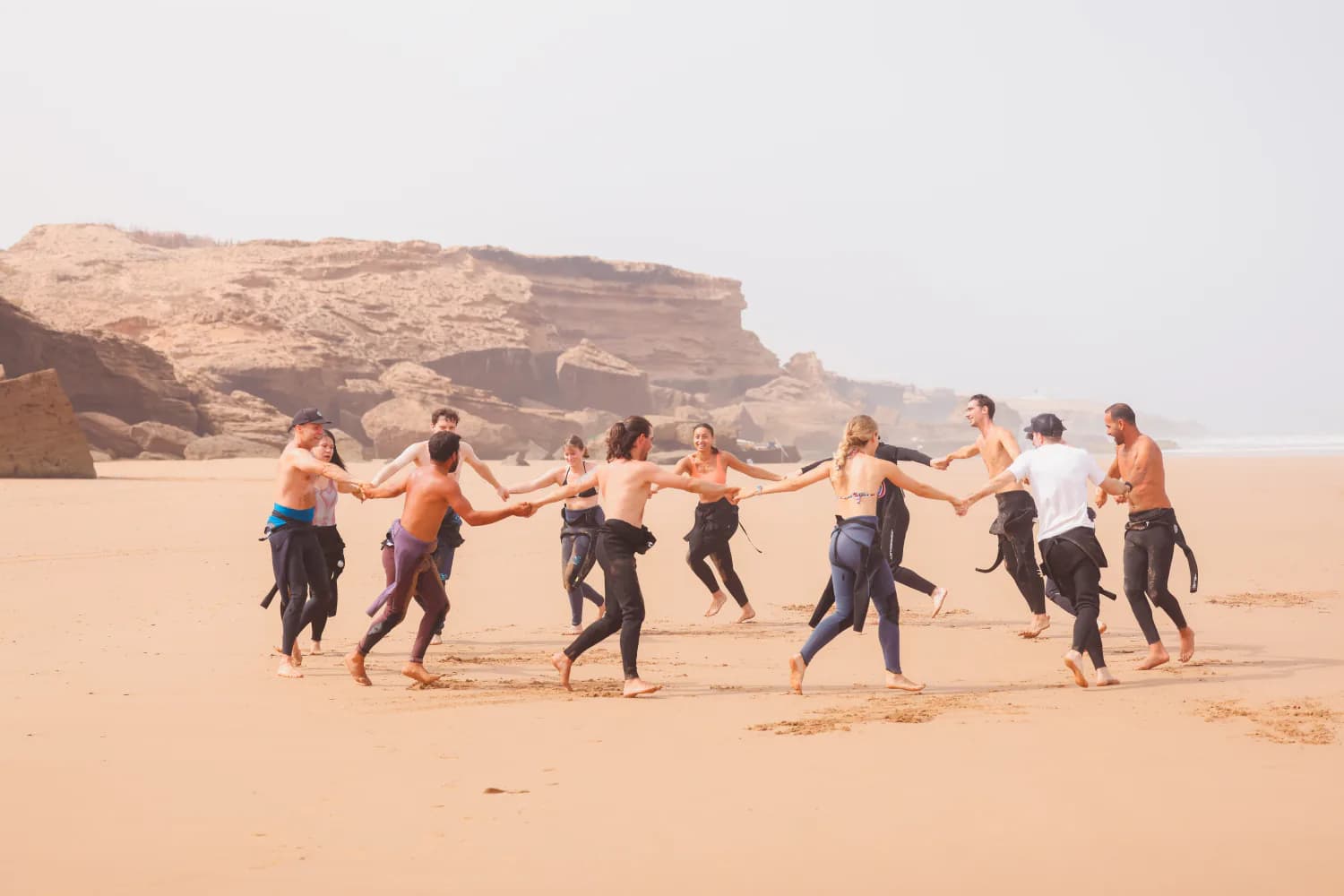 Un groupe de cours courant ensemble pendant l’échauffement sur la plage.