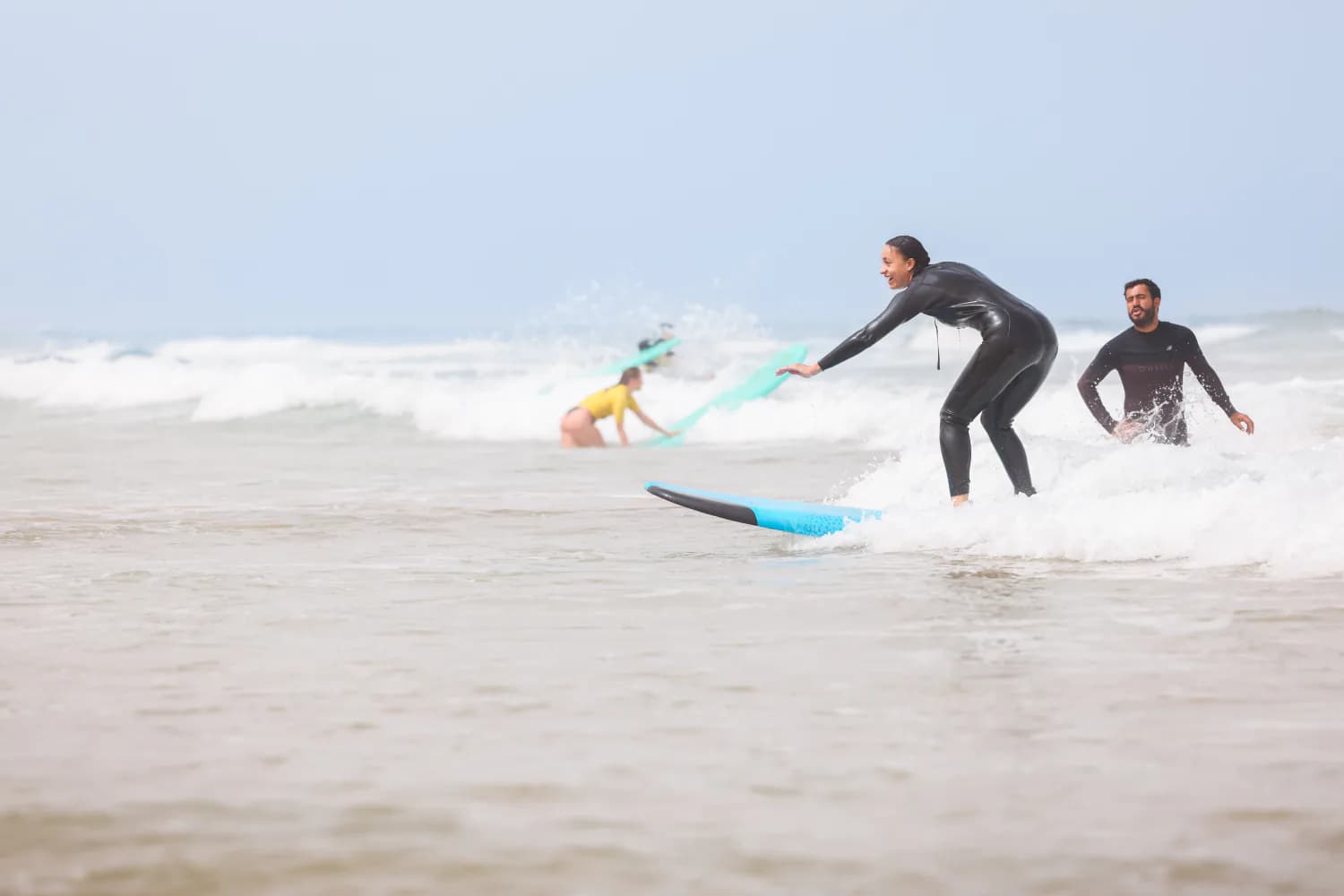 Une débutante surfant une petite ligne de mousse vers le rivage.